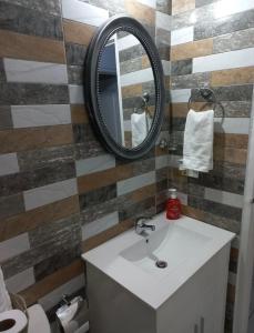 W łazience znajduje się umywalka i lustro. w obiekcie Mi Casa Comfort Estate w mieście Portmore