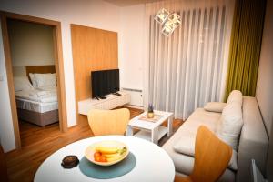a living room with a couch and a table with a bowl of fruit at Zlatibor apartman in Zlatibor