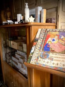 a display case in a store with a counter top with a rug at Maison d'Hôtes & Savonnerie de Bonnefon in Saint-Chély-dʼAubrac