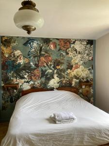 a bedroom with a floral wallpaper with a bed at Maison d'Hôtes & Savonnerie de Bonnefon in Saint-Chély-dʼAubrac