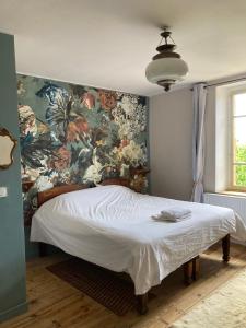 sypialnia z dużym łóżkiem i tapetą w kwiaty w obiekcie Maison d'Hôtes & Savonnerie de Bonnefon w mieście Saint-Chély-dʼAubrac
