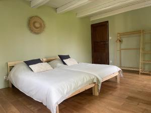 a large bed with white sheets and pillows in a room at Domaine Saperlipopette in Baincthun