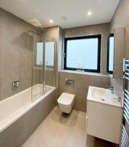 y baño con aseo, lavabo y ducha. en SoHot Stays Sail Apt Sea Views Ground Floor Free Parking en Ramsgate