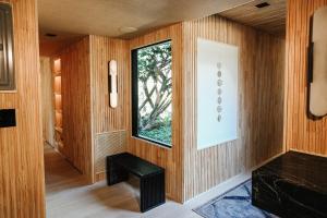 Cette chambre dispose de murs en bois, d'une fenêtre et d'un banc. dans l'établissement Stunning Villa in Princeton, NJ, à Princeton