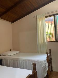 1 dormitorio con 2 camas y ventana en Cabañas Ecologicas Cayapas, en Atacames