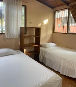 2 camas en una habitación con 2 ventanas en Cabañas Ecologicas Cayapas, en Atacames
