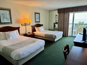 a hotel room with two beds and a balcony at Boardwalk Beach Resort in Myrtle Beach