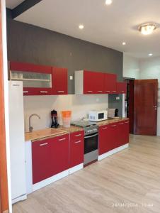 a large kitchen with red cabinets and a sink at Luxe Villa in Cotonou