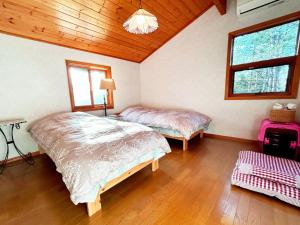 1 dormitorio con 2 camas y techo de madera en villa mori no wankororin - Vacation STAY 69614v en Tsumagoi