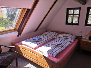 ein Schlafzimmer mit einem Bett im Dachgeschoss in der Unterkunft Chalupa Adélka in Hejnice
