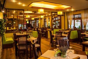 a restaurant with wooden tables and green chairs at Hotel Riviera in Sinaia