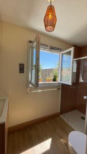 een badkamer met een toilet en een raam bij Le Bayanas in La Rochelle