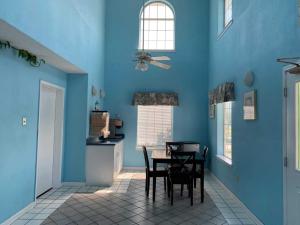 a dining room with blue walls and a table and chairs at Key West Inn - Chatsworth in Chatsworth