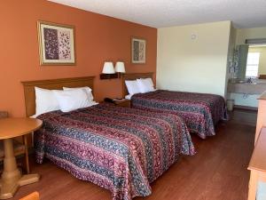 a hotel room with two beds and a table at Key West Inn - Chatsworth in Chatsworth