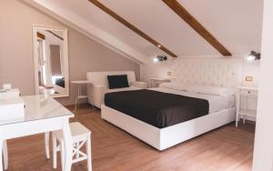 una camera bianca con letto e scrivania di Fata34 Luxury B&B a Reggio di Calabria