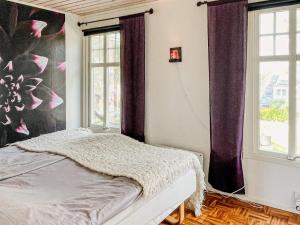 - une chambre avec un lit dans une pièce dotée de fenêtres dans l'établissement Holiday home MÖNSTERÅS VII, à Mönsterås
