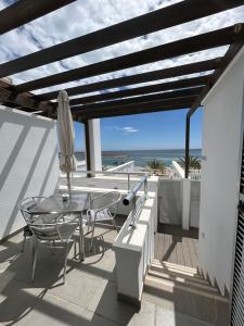 patio ze stołem i parasolem oraz oceanem w obiekcie Balcón azul w mieście Carboneras