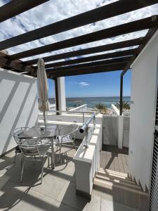 un patio con una mesa y una sombrilla y el océano en Balcón azul, en Carboneras