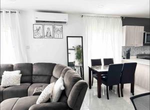 a living room with a couch and a table at Comfortable Stay In Phoenix Estate in Portmore