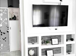 białe centrum rozrywki z telewizorem z płaskim ekranem w obiekcie Comfortable Stay In Phoenix Estate w mieście Portmore