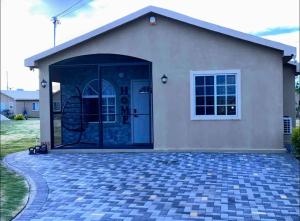 a house with a large door and a patio at Comfortable Stay In Phoenix Estate in Portmore