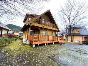 a large wooden house with a large deck at Hot Spring Resort Usui Pass Forest Park "Natural H - Vacation STAY 54904v in Karuizawa