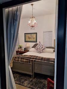 1 dormitorio con cama y lámpara de araña en Acacia Home en Graaff-Reinet