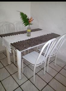 a table with white chairs and a potted plant on it at Camburi Casa Shamballa in São Sebastião +14 photos