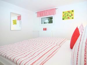 ElpeにあるWonderful Apartment in Elpe with Gardenの白いベッドルーム(ベッド1台、赤い枕付)