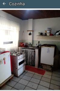 a kitchen with two refrigerators and a stove in it at Camburi Casa Shamballa in São Sebastião