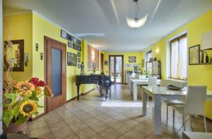 una sala da pranzo con pareti gialle e pianoforte di B&B-FORESTERIA Casa Della Musica Lake Como a Mandello del Lario