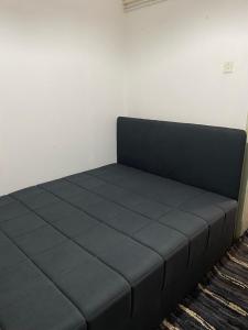 a black bed in a room with a wall at BT Apartments in Strumica +1 photo