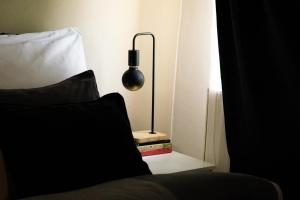 una lámpara sentada en una mesita de noche junto a una cama en Cozy studio apartment in New Town with Disney+ en Praga