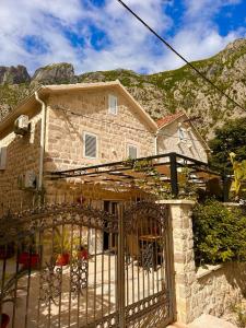 a stone house with a gate and a mountain at Holiday Home Nautica in Kotor