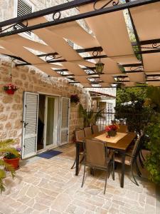 an outdoor patio with a wooden table and chairs at Holiday Home Nautica in Kotor