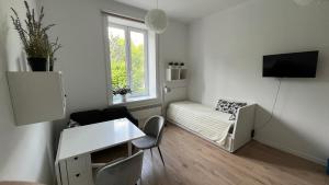 una pequeña sala de estar con sofá y ventana en Good Vibes Only, en Cracovia