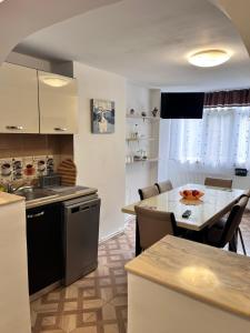 eine Küche mit einem Tisch und einem Esszimmer in der Unterkunft Apartament Maria 1 in Băile Herculane