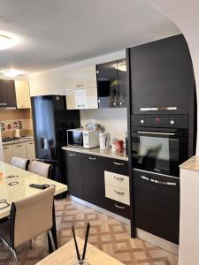 eine Küche mit einem großen schwarzen Ofen und einem Tisch in der Unterkunft Apartament Maria 1 in Băile Herculane + 22 Fotos