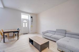a living room with a couch and a table at Les merveilles de la palmyre in Saint-Ciers-sur-Gironde