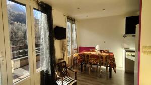una sala da pranzo con un tavolo e una cucina di Résidence Saint Genest - Appartement proche Village 4 pers MAE-1911 a Vallouise