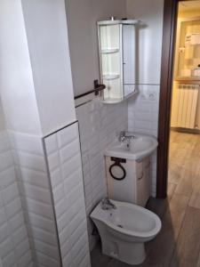 La salle de bains blanche est pourvue de toilettes et d'un lavabo. dans l'établissement MBR-Napoli, à Naples