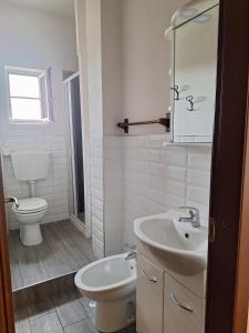 La salle de bains blanche est pourvue de toilettes et d'un lavabo. dans l'établissement MBR-Napoli, à Naples