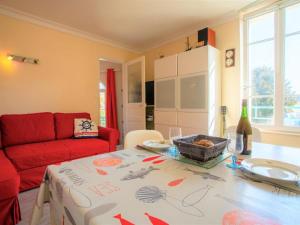 Le Celtic في دينارد: غرفة معيشة مع طاولة وأريكة حمراء