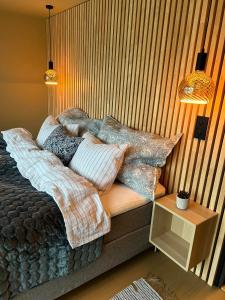 Un dormitorio con una cama con almohadas. en Perle ved sjøen! Ny hytte på 90m2., en Kragerø