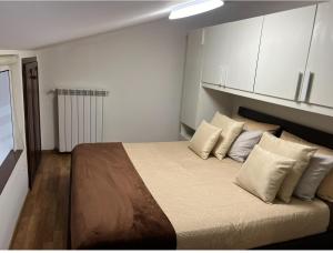 a bedroom with a large bed with white cabinets at Petite maison in Fiumicino