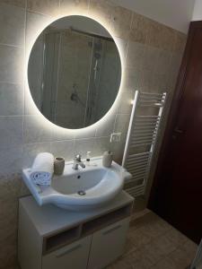 W łazience znajduje się umywalka i lustro. w obiekcie Reversal apartment w mieście Santa Marinella