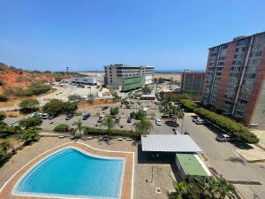 een uitzicht over een zwembad op een parkeerplaats bij Apartamento para viajeros Aeropuerto Maiquetia in Catia La Mar