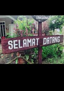 a wooden sign that reads se lanart draining at Langkawi homestay in Pantai Cenang