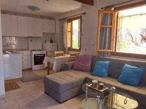 a living room with a couch and a kitchen at Pitini Nikos house in Symi