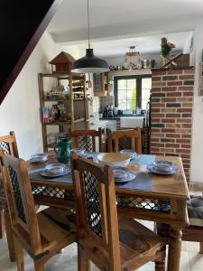 een keuken en eetkamer met een houten tafel en stoelen bij Stéph&Marry House Brodina 